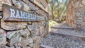 Un muro de piedra con un letrero que dice 'RAMSHED CREEK'.