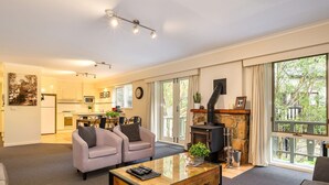 Amplia sala de estar con chimenea, comedor y cocina.