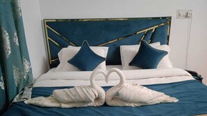 A bed with a blue headboard, white bedding, and two pillows. - HOTEL WEST INN BOULEVARD (Srinagar)