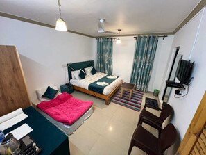 Cozy retreat with a single bed, wooden desk, and mounted TV.