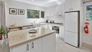 Een koffiezetapparaat/waterkoker, kookgerei, borden en bestek