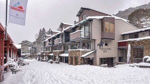A snow-covered street with buildings, including a sign for Squatter's Run.