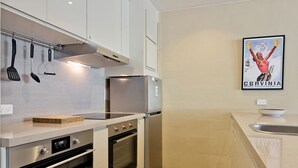 A modern kitchen with stainless steel appliances, a built-in oven, and a wall-mounted spice rack.
