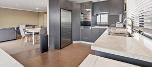 Enjoy cooking in this well-equipped kitchen with a refrigerator, ovens, and microwave.