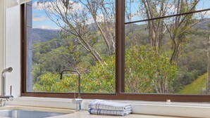 A bathroom with a large window, a sink, and a towel.