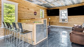 A wooden interior with a bar area, chairs, and a couch. - Lake Escape w/ Hot Tub & Docks in Hope! (Hope)