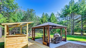 Un patio in legno con una pergola e zona salotto all'aperto.