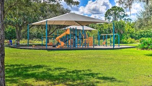A playground with a shaded play area, surrounded by grass and trees. - Renovated Rotonda West Oasis w/ Private Pool (Rotonda West)