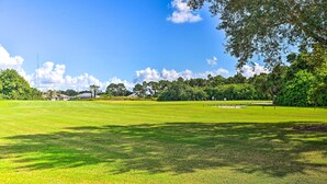 A golf course with a clear sky, lush greenery, and a well-maintained fairway. - Renovated Rotonda West Oasis w/ Private Pool (Rotonda West)