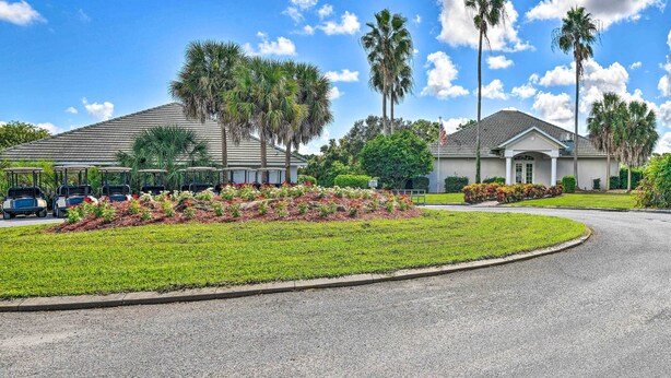 A residential area with two houses, a driveway, and a golf cart parking area. - Renovated Rotonda West Oasis w/ Private Pool (Rotonda West)