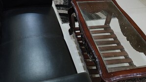 Una camera da letto con un letto, comodini, un divano nero e un tavolino in legno.