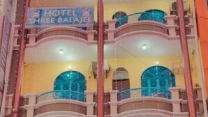 Un hotel con un cartello che riporta 'HOTEL SHREE BALAJEE' e balconi dotati di ringhiere blu.