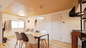 Una cocina moderna con estufa a gas, armarios de madera y un comedor con mesa y sillas de madera.