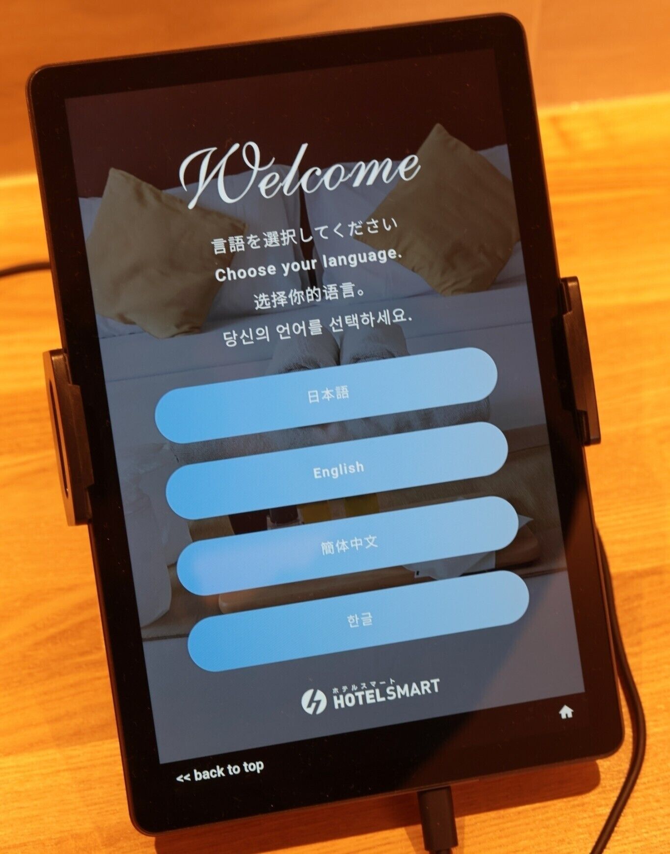 Um tablet exibindo uma interface de seleção de idioma com opções para japonês, inglês e chinês.