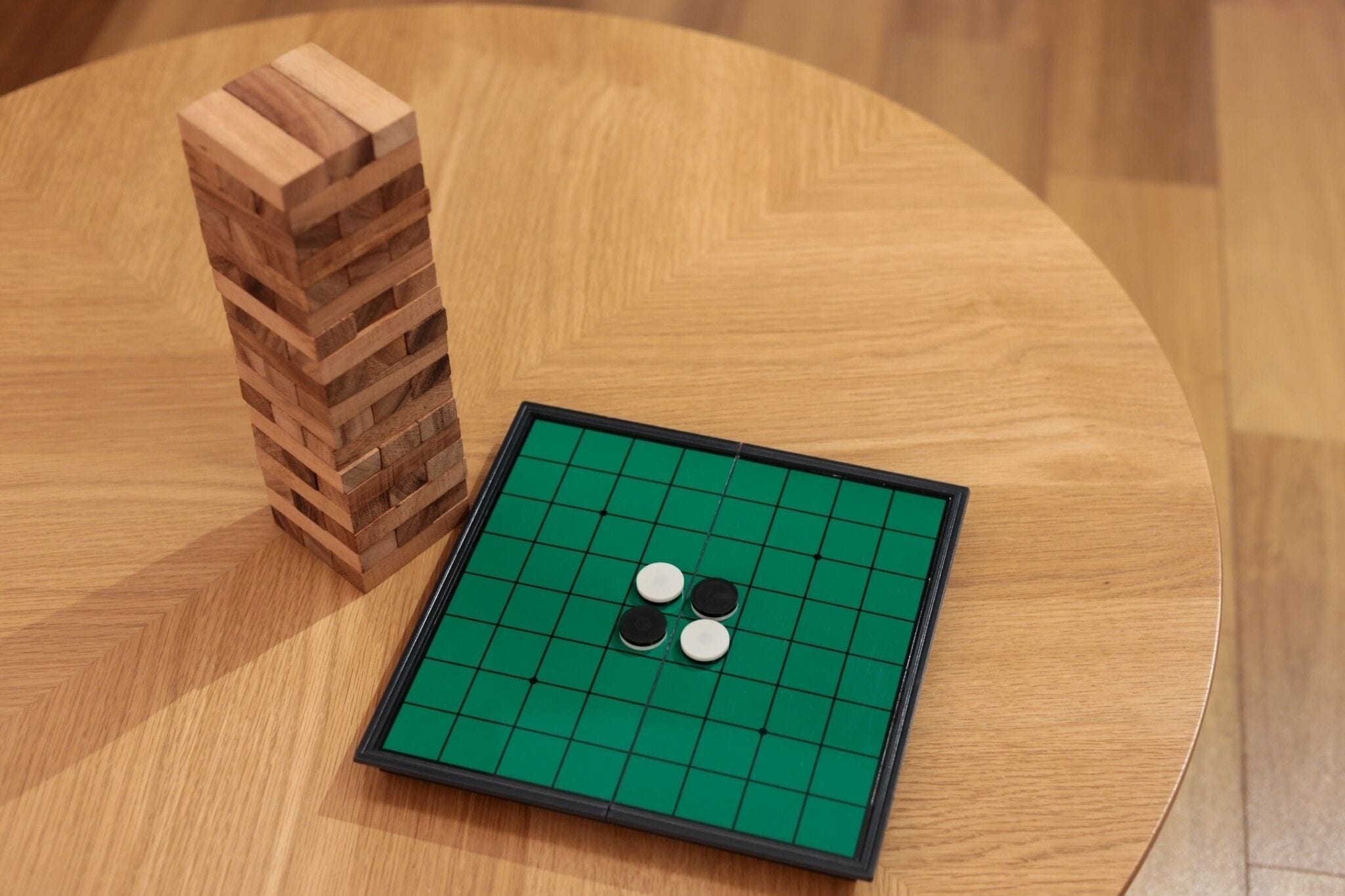 Un tablero de Go con dos piedras sobre una mesa de madera.