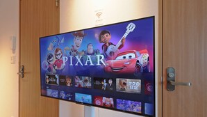 A flat-screen TV mounted on a wall displaying the Pixar logo and characters from 'Cars' and 'Cars 2'. - V.Close to Shinjuku Kabukicho E (Shinjuku-ku)