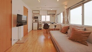 A compact living space with a kitchenette, a sofa, and a television. - V.Close to Shinjuku Kabukicho E (Shinjuku-ku)