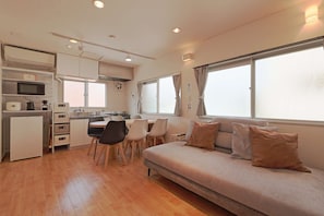 A compact living space with a kitchenette, a dining area, and a sofa.