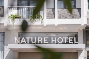 Un letrero de hotel con el nombre 'NATURE HOTEL' en letras grandes y mayúsculas.