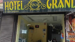 Ein Hotel Eingang mit einem Schild, auf dem 'HOTEL GRAND' und 'SNA' steht.