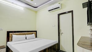 Ein Schlafzimmer mit Bett, Schrank, Tür und Klimaanlage.