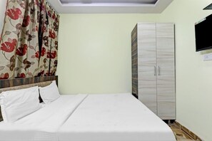 A bedroom with a bed, a wardrobe, a television, and a skylight. - Hotel SNA Grand (Lucknow)