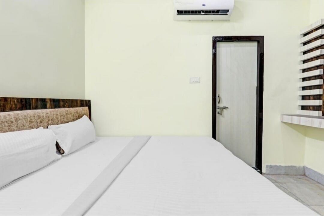 Ein Hotelzimmer mit einem Bett, einer Tür und einer Klimaanlage.