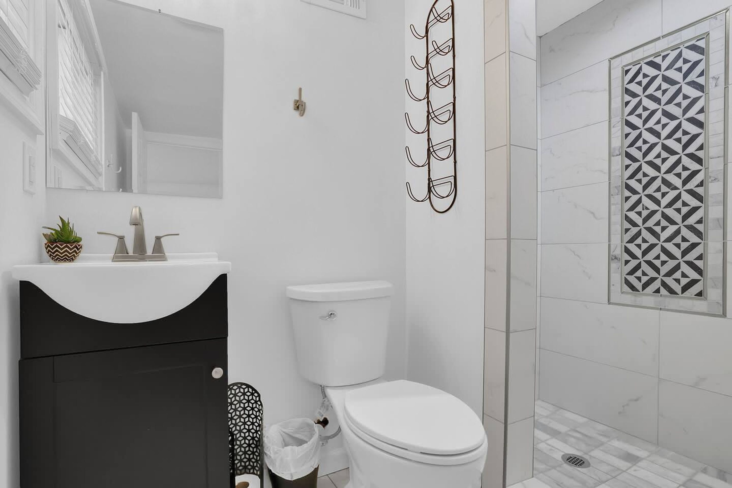A bathroom with a toilet, sink, and shower.
