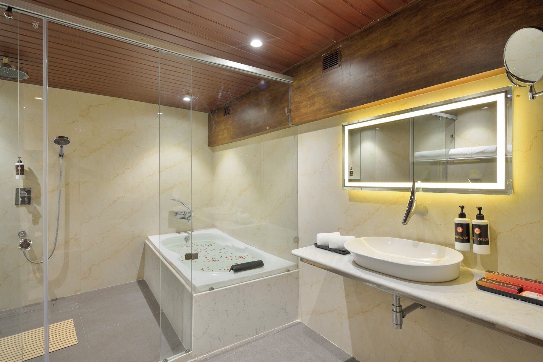 A modern bathroom with a glass-enclosed shower, a freestanding bathtub, a vanity with a sink, and a mirror.