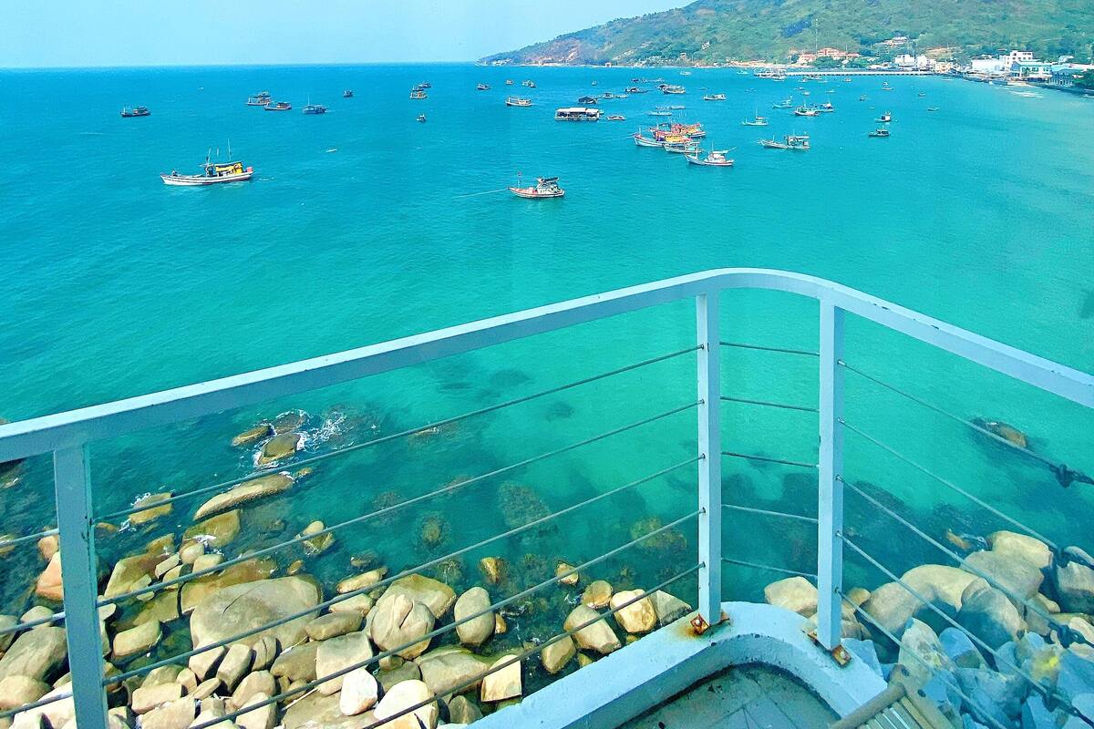 A coastal view with boats on the water and a rocky shoreline.