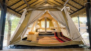 A tent with a bed, a table, and a chair inside. - iRETREAT Jungle Bliss Pa Pae (Mae Taeng)