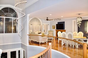 A spacious living area with a high ceiling, a wooden staircase, and a dining set. - Bear Mountain Getaway close to the golf course
 (Victoria)
