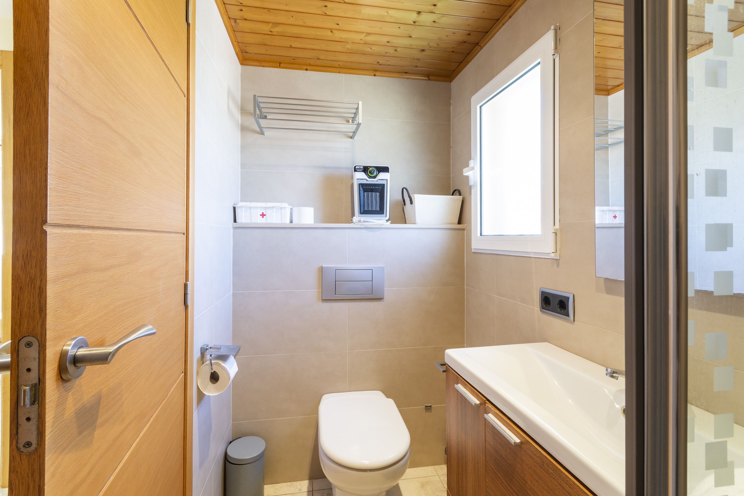 A compact bathroom with a toilet, sink, and shower area.