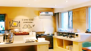 A kitchen area with a wall sign that reads "I love egg let's get cooking!" and a window with curtains. - East Maples Inn Wanda (Wuxi)