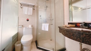 A modern bathroom with a glass-enclosed shower, a white toilet, and a marble sink. - East Maples Inn Wanda (Wuxi)