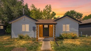 A two-story house with a porch, a front door, and a small front yard. - Crow peak Cabin: Peaceful stay (Spearfish)