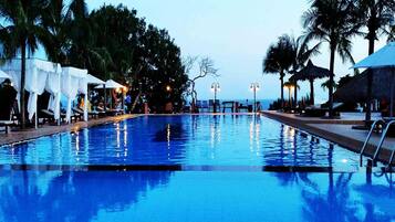 Una piscina al aire libre, camas de piscina gratis, sombrillas