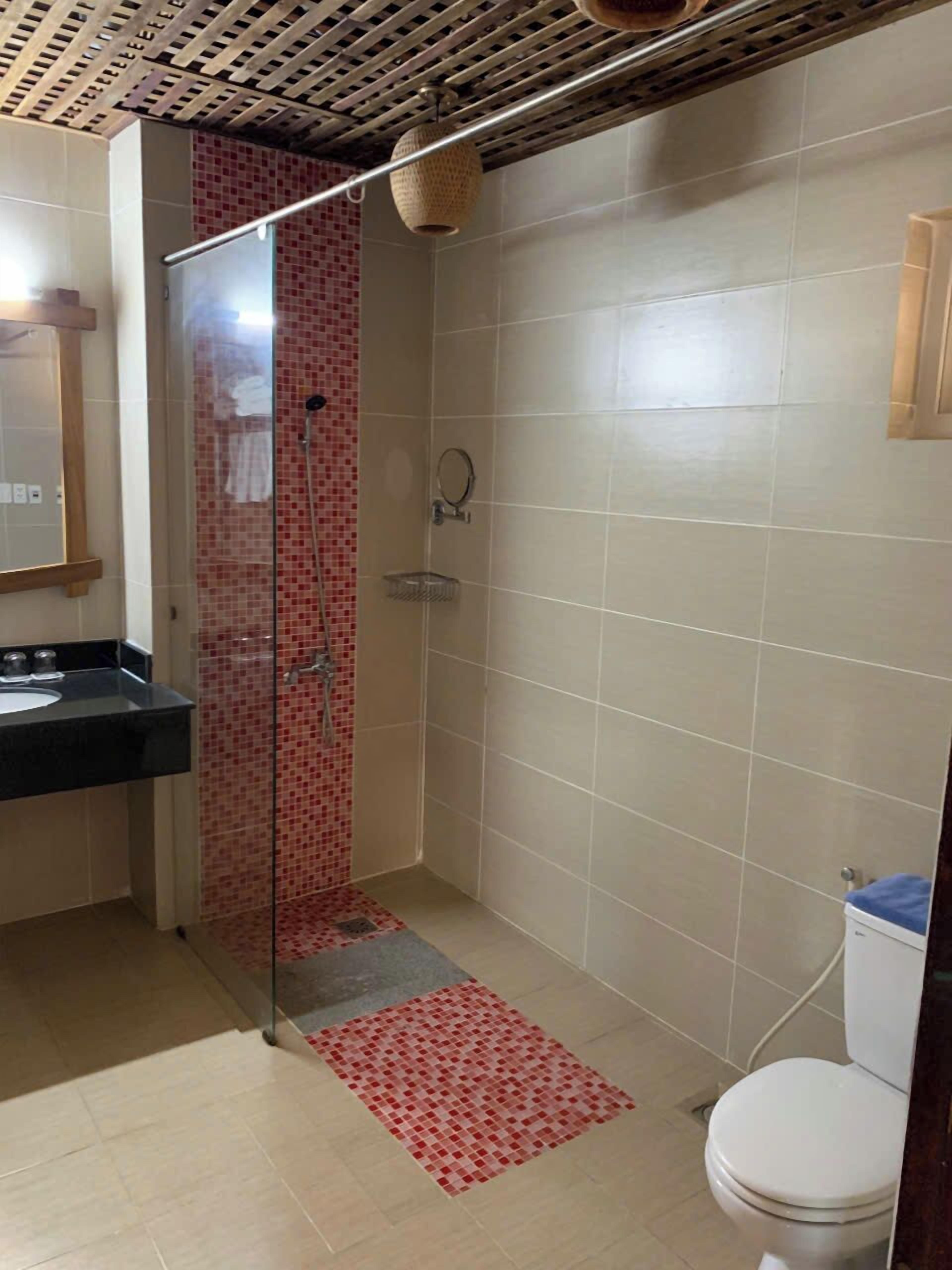 A bathroom with a shower, toilet, and sink.