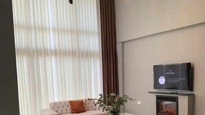 Un salon moderne avec un canapé, une table basse et un téléviseur fixé au mur.