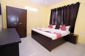 A bedroom with a bed, a wardrobe, a bedside table, and a curtain.