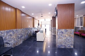 A reception area with a reception desk, chairs, and a wooden wall.