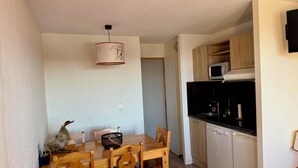 Eine kompakte Küche mit Mikrowelle, Geschirrspüler und Holzschränken.