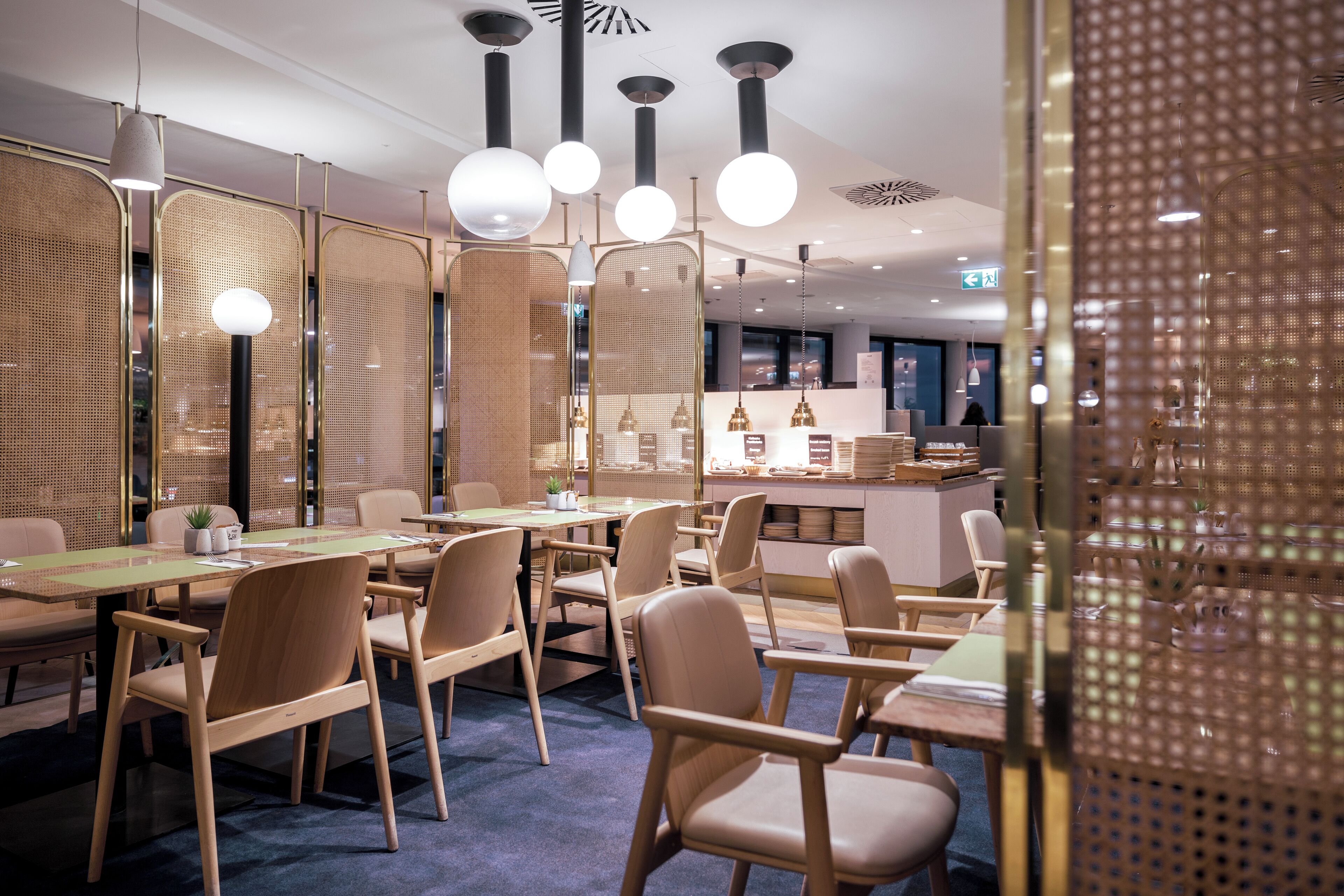 A modern dining area with wooden furniture and pendant lighting.