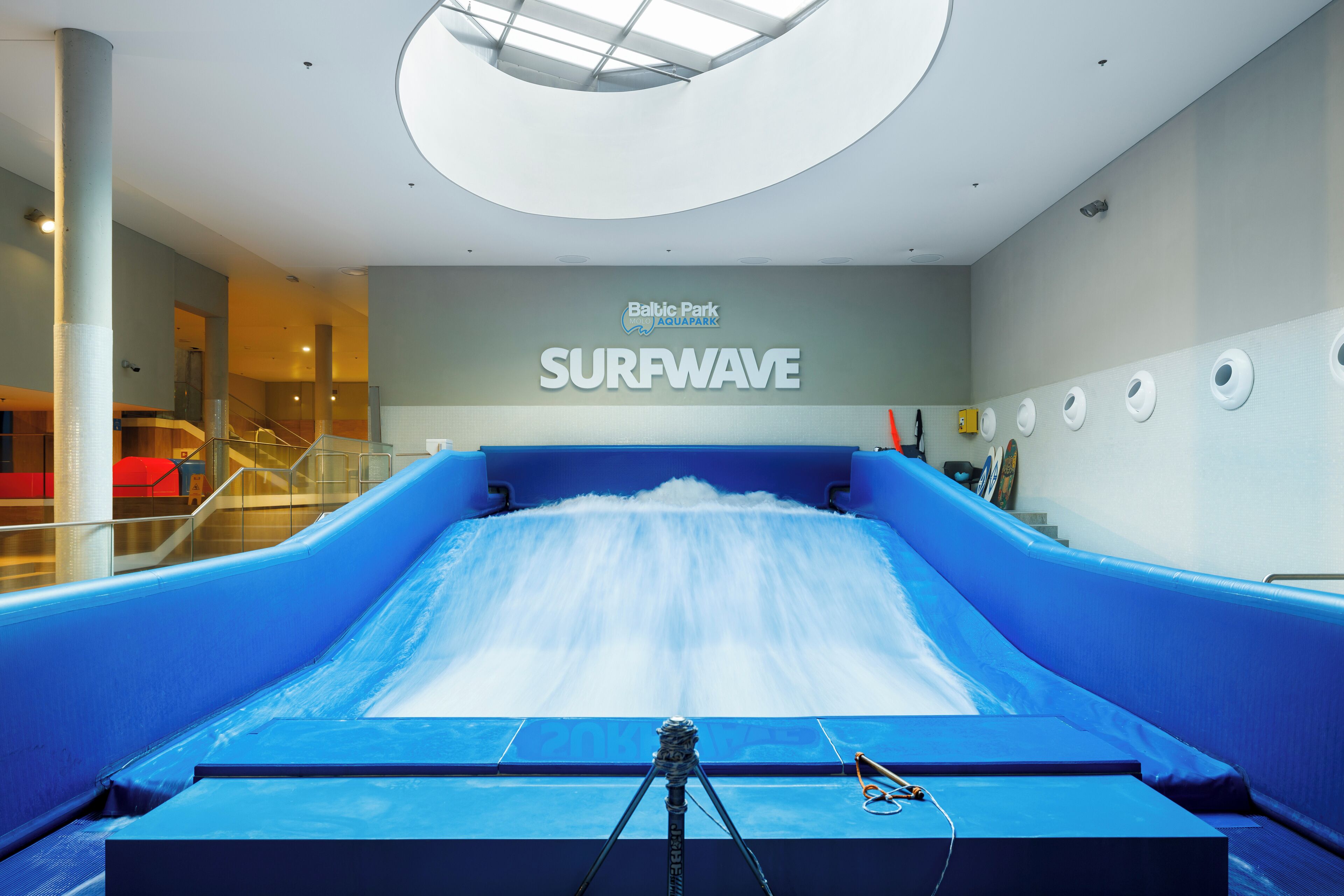 Simulador de olas en el interior del Baltic Park Aquafarm, con un tobogán azul grande y un flujo de agua visible.