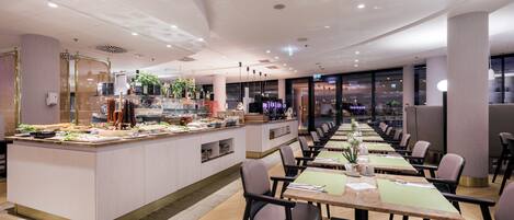 Un restaurante moderno con una barra alargada, varias mesas y sillas.