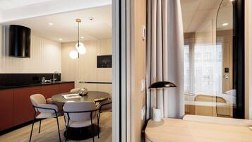 Una habitación de hotel moderna con comedor, cocina y sala de estar separada.