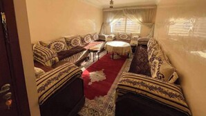 A room with a sofa set, a small round table, and a patterned rug. - Spacious and comfortable Moroccan apartment (Temara)