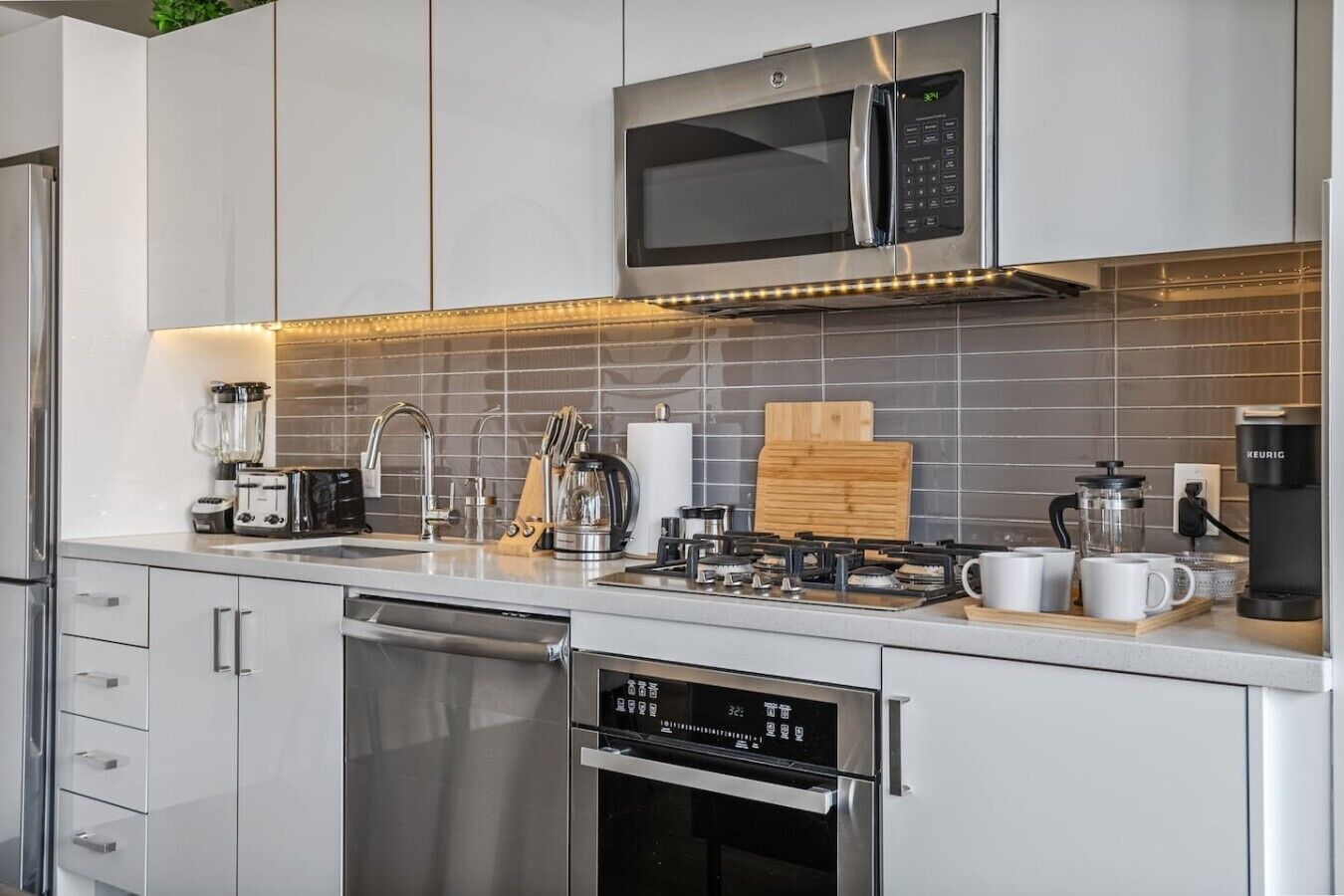 Una cocina moderna con electrodomésticos de acero inoxidable, lavavajillas y cafetera.