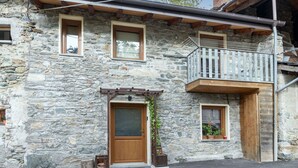 A stone building with a wooden door, a balcony with a metal railing, and two windows. - Stunning  villa for 5 people with WIFI, TV, patio and pets allowed (Chez Croiset)