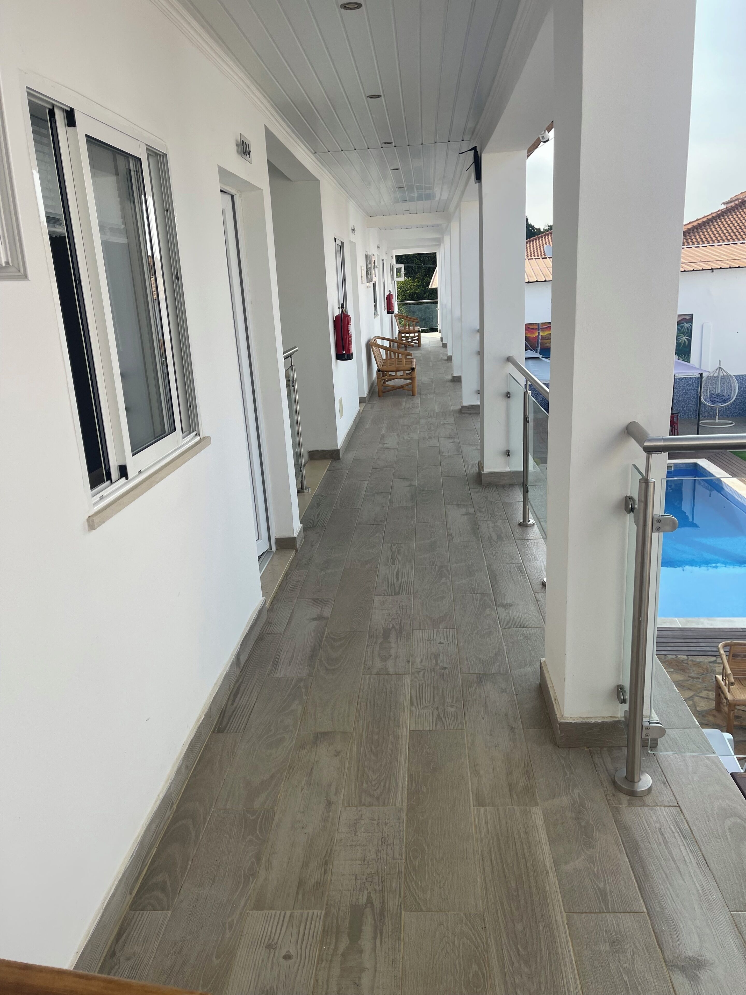 A corridor with a pool area visible through glass doors.